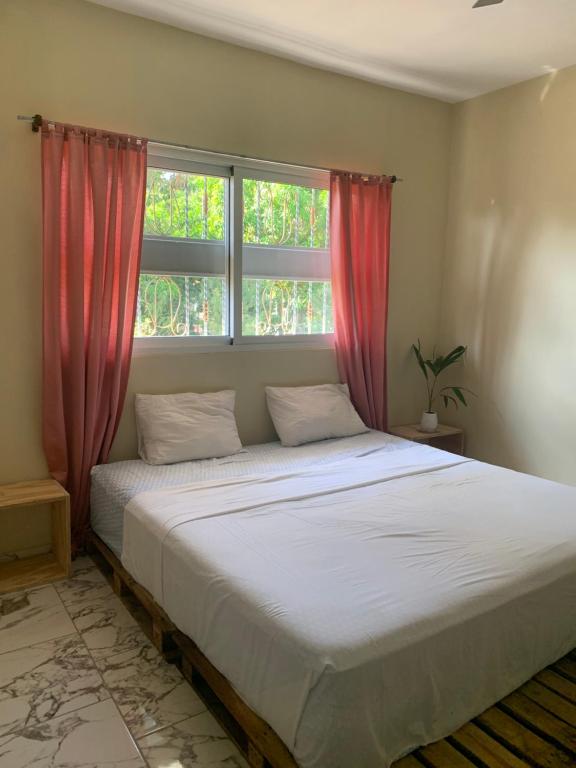 a bedroom with a large bed with red curtains at Hermosa casa en Cabarete, Villa Esperanza in Cabarete