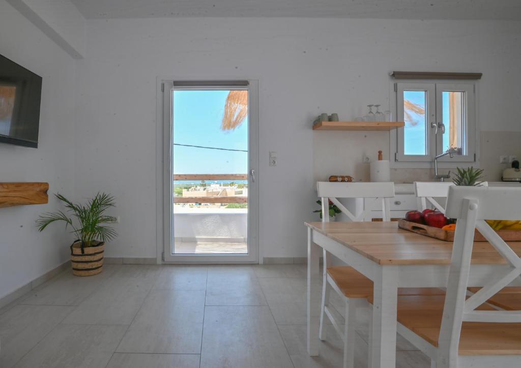 biała kuchnia ze stołem i widokiem na ocean w obiekcie Pregadi Cycladic Suite w mieście Naksos