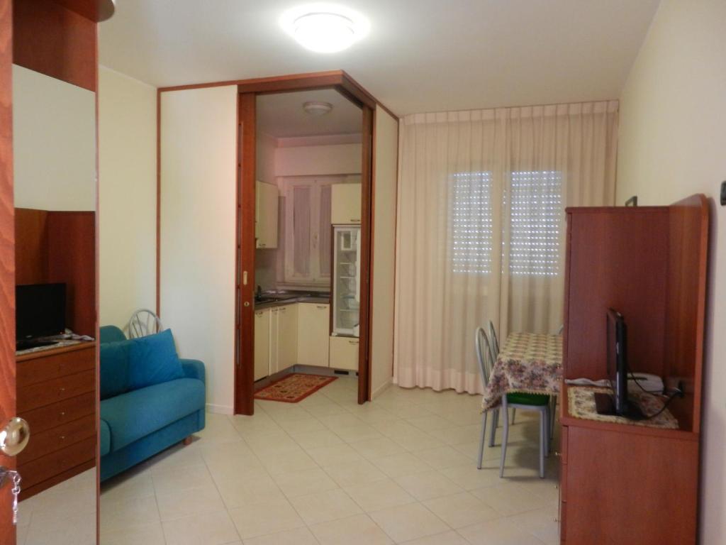 een woonkamer met een blauwe bank en een tafel bij Residence Xenia in Alba Adriatica