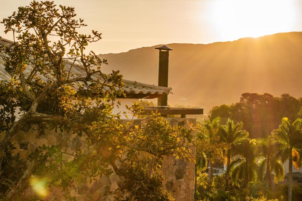 a house with the sun in the background at Lofts Villa Gratiam in Tiradentes