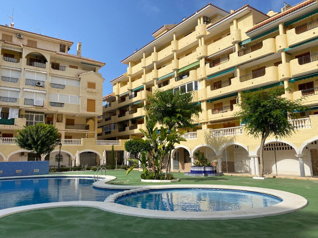 a large apartment building with a large swimming pool at La Mata beach apartment Viñamar I, 200m from the beach in La Mata