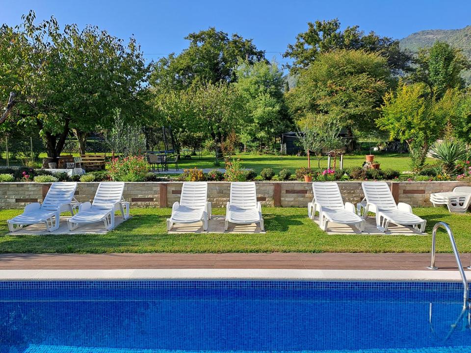 a row of lounge chairs next to a swimming pool at Studio Apartments Petkovic in Tivat