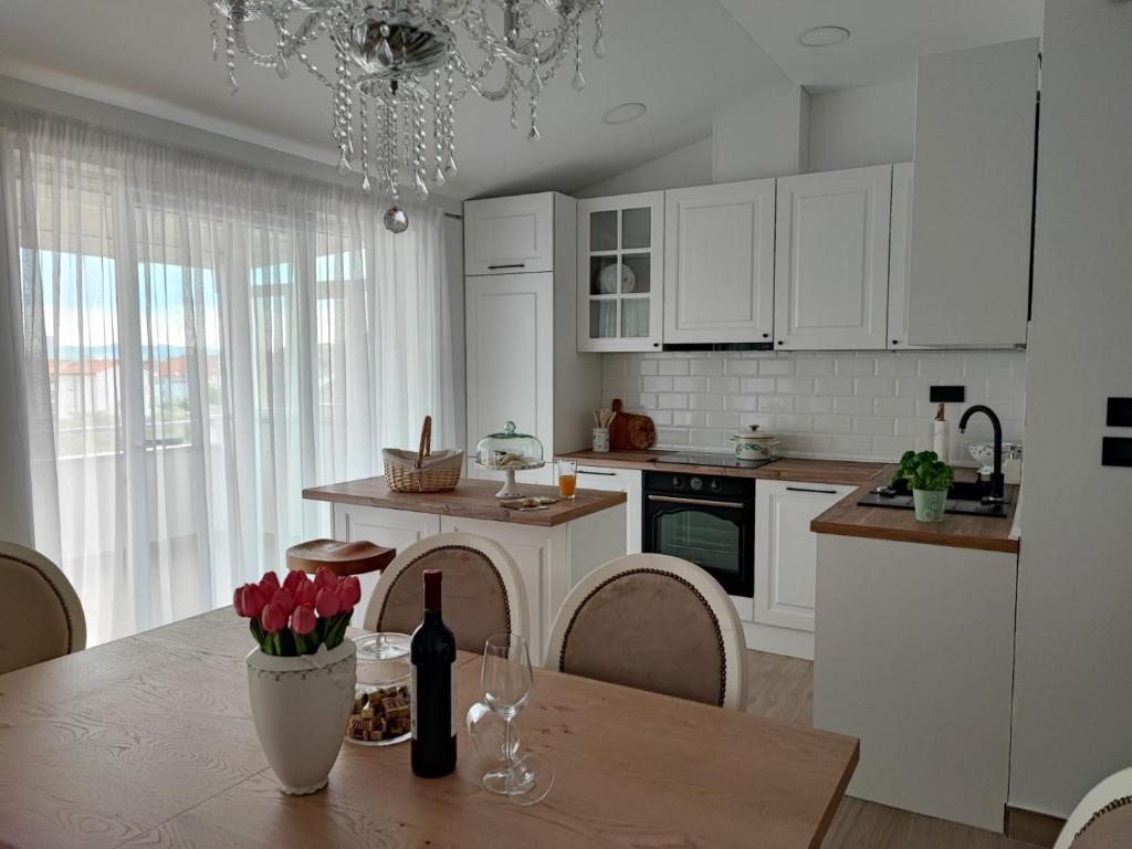 - une cuisine avec des placards blancs et une table fleurie dans l'établissement SPLIT VIEW 2 Bedrooms LUXURY APARTMAN 90 m2, à Klis