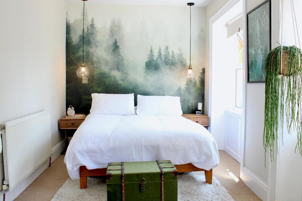 um quarto com uma cama branca e uma mala verde em Cobbles Cottage, Honley em Honley