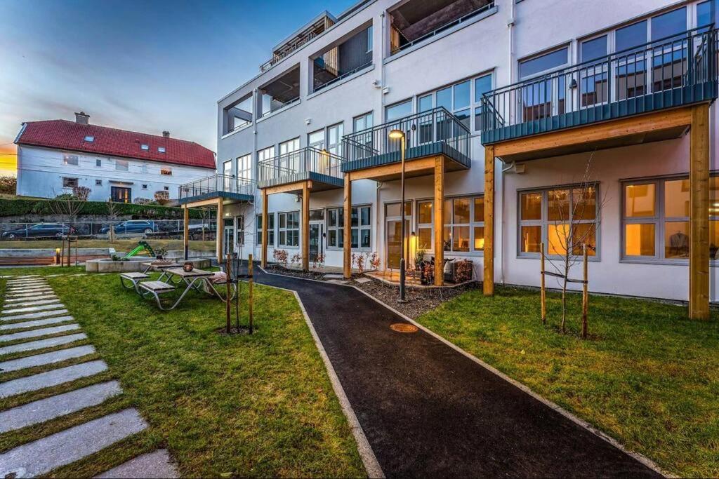 a large white building with a patio and a yard at Apartment in Breiviken in Bergen