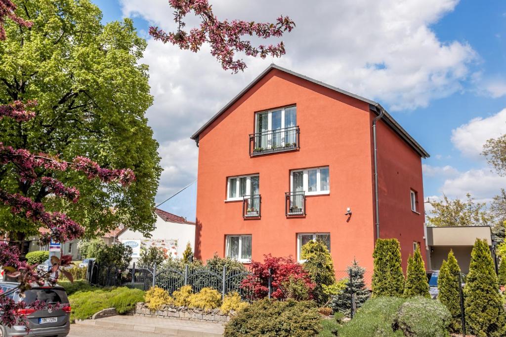 a red brick house with a car parked in front of it at Elendris - Ubytování u kostela in Brno