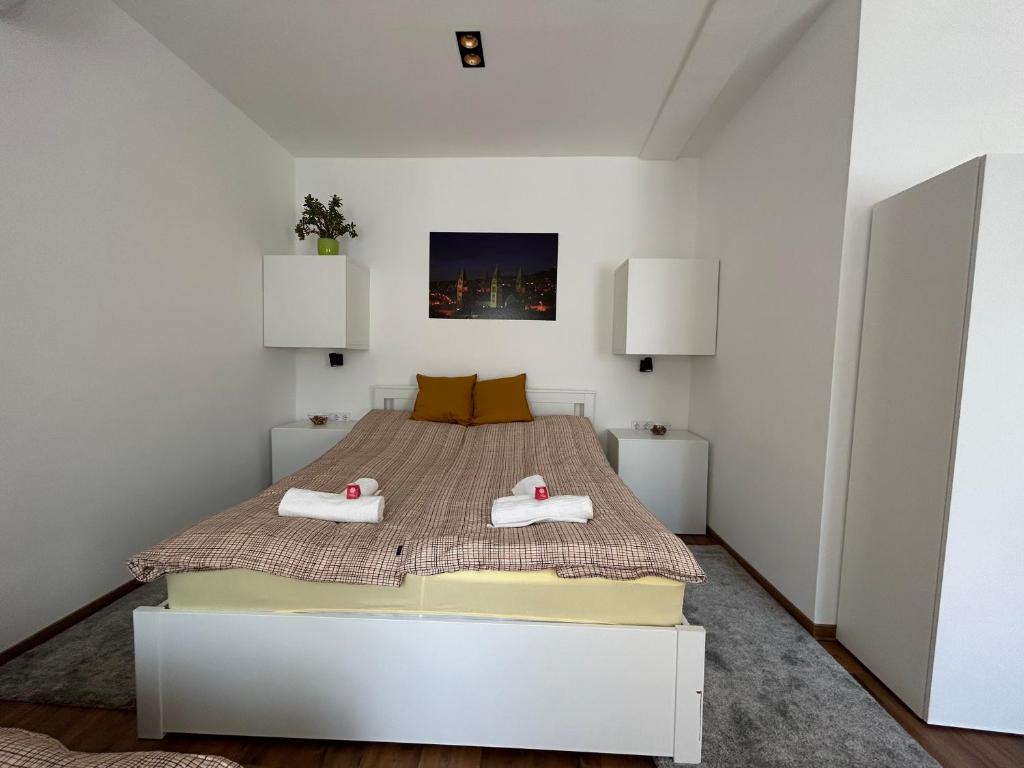 een slaapkamer met een bed met twee handdoeken erop bij R59 Apartman with free parking in Pécs