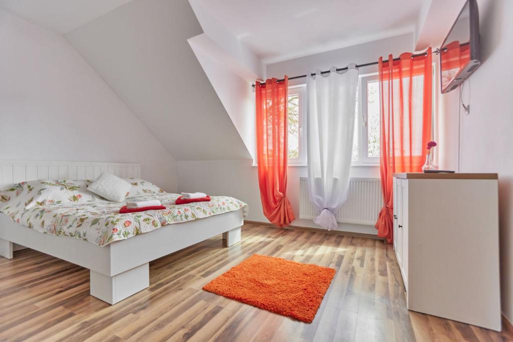a white bedroom with a bed and a orange rug at Krab in Rewal