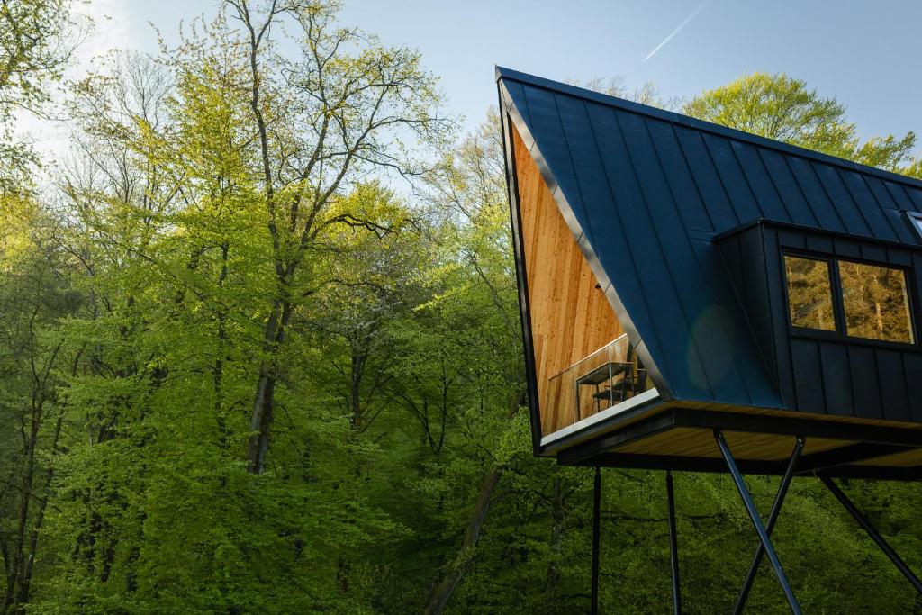 una casa en el árbol con techo azul en Baumhausapartment, en Breuberg