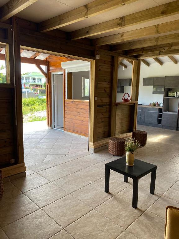 um alpendre coberto com uma mesa e um quarto em Le Chalet des Rêves Ensoleillés em Saint-François