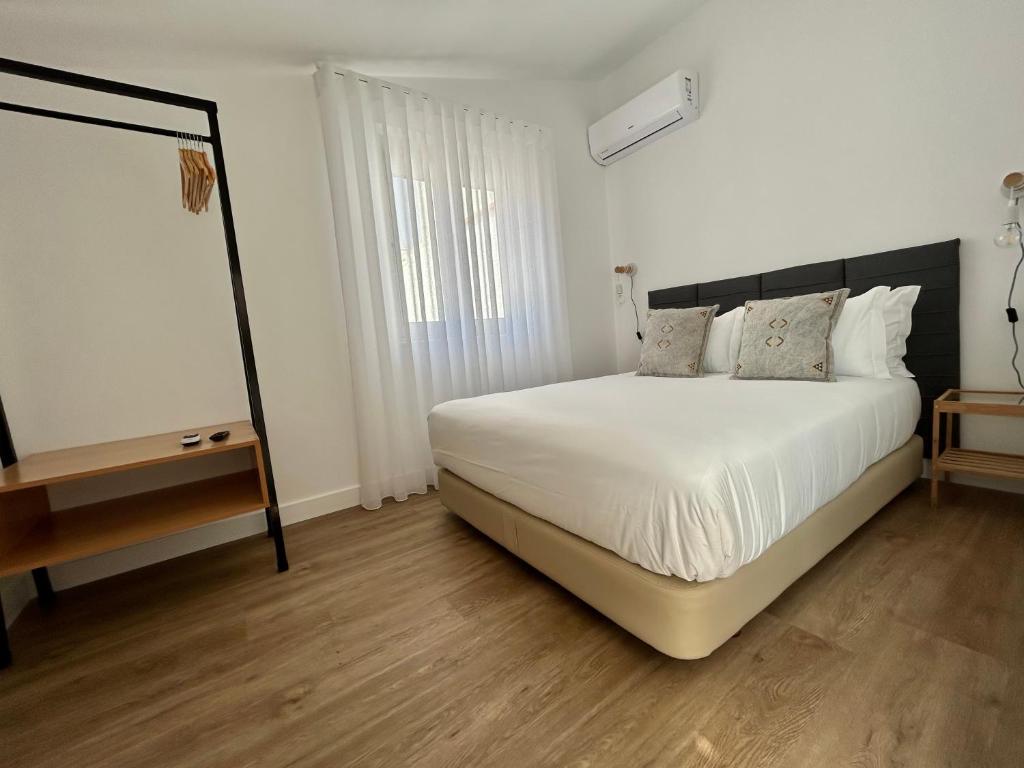 - une chambre avec un lit blanc et du parquet dans l'établissement Casas da Praia, à Furadouro