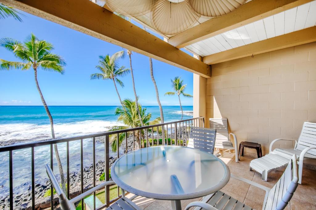balcón con mesa y sillas y la playa en Kona Bali Kai #318, en Kailua-Kona