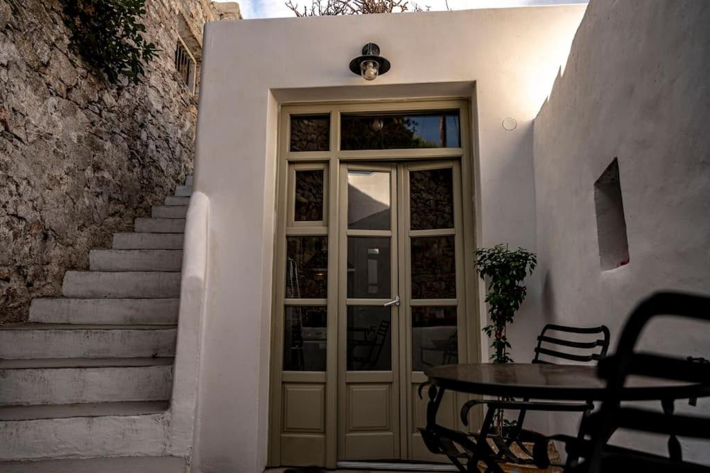 a door with a table in front of a building at mikro.kastro kalotaritissa in Chora Amorgos in Amorgos
