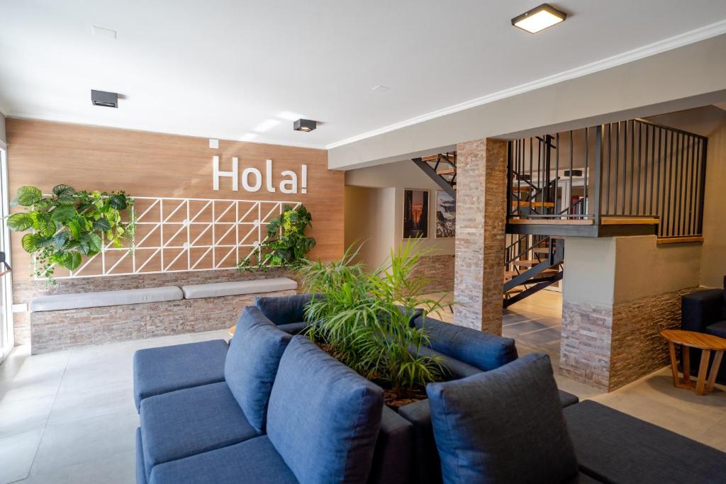 un hall d'un hôtel avec des canapés bleus et des plantes dans l'établissement Nuevo Centro Hotel Villa Carlos Paz, à Villa Carlos Paz