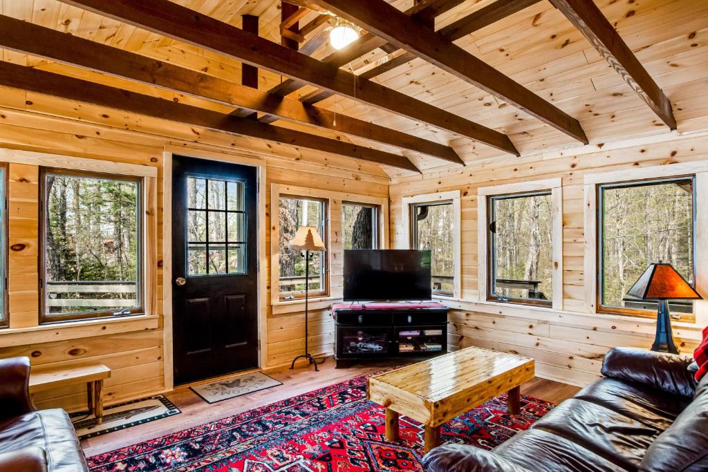 een woonkamer in een blokhut met een bank en een tv bij Three Bears Lodge in Boulder Junction