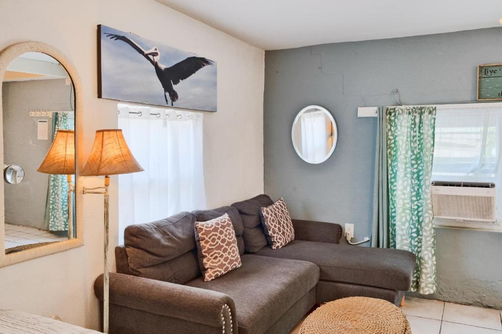 a living room with a couch and a mirror at Shortboard in Holmes Beach