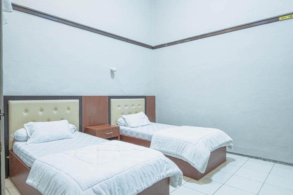 En eller flere senge i et værelse på Kartika Syariah Guest House