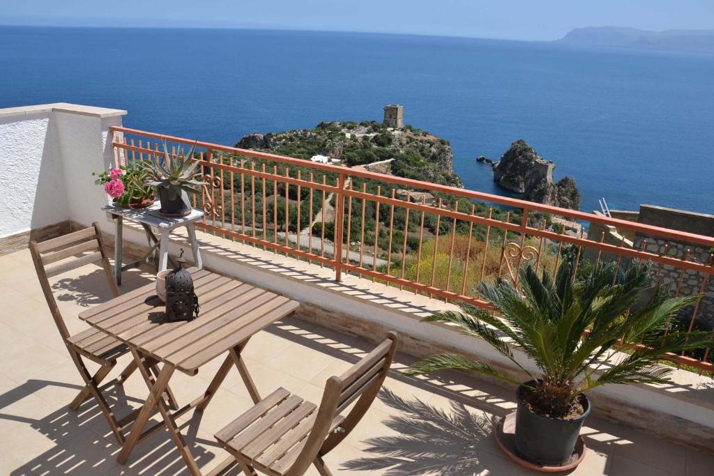 balcone con tavolo, sedie e vista sull'oceano di B&B Talìa a Scopello