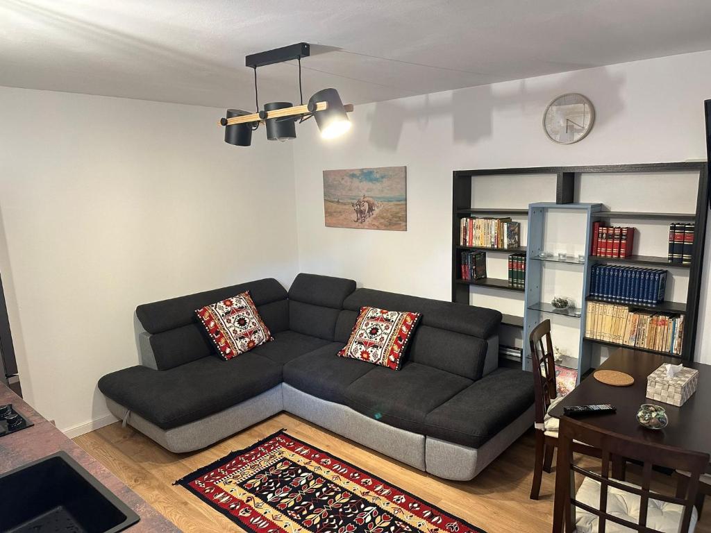 a living room with a black couch and a table at Tiny Traditional House in Bucharest