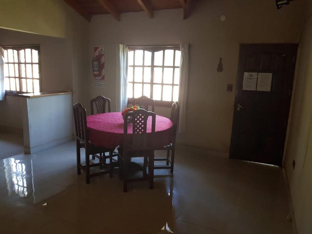 una sala da pranzo con tavolo e sedie rosa di EUCASOL a San José