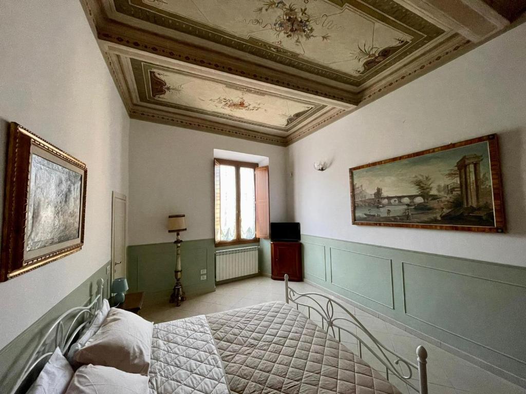 a bedroom with a bed and a painting on the ceiling at Appartamento Sant'Ambrogio in Florence