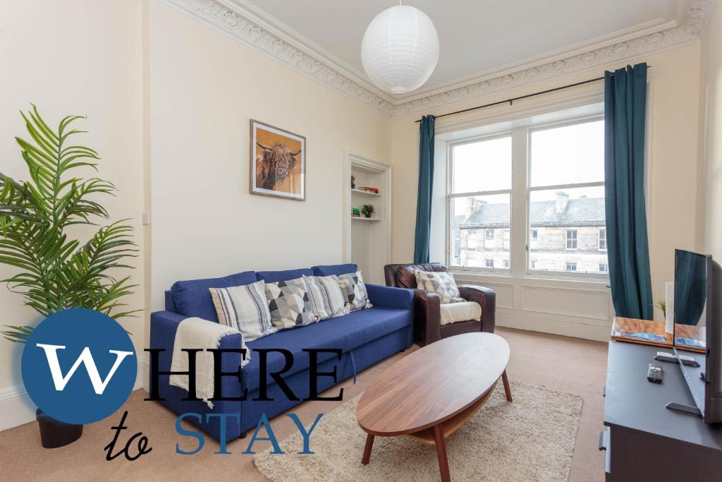 a living room with a blue couch and a table at Delightful 2 bedroom apartment in Leith in Edinburgh