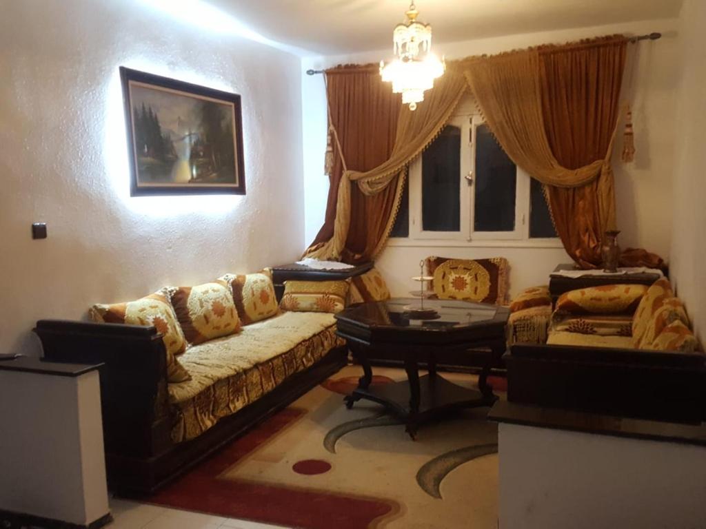 un salon avec un canapé et une table dans l'établissement Appartement Familial en face le grand stade de tanger, à Tanger