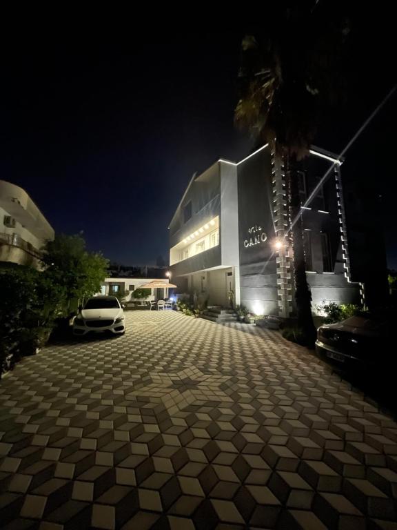 a parking lot in front of a building at night at Vila Cano in Durrës