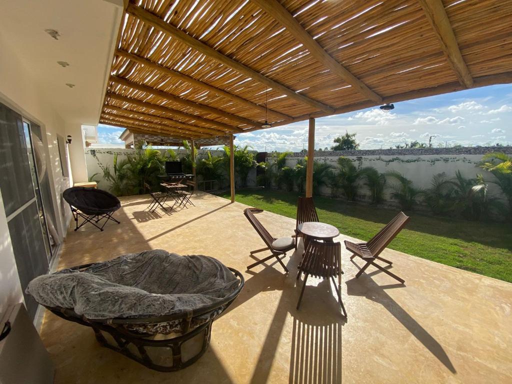 a patio with chairs and a bed and a view at Villa Campestre Bavaro-Punta Cana in Punta Cana