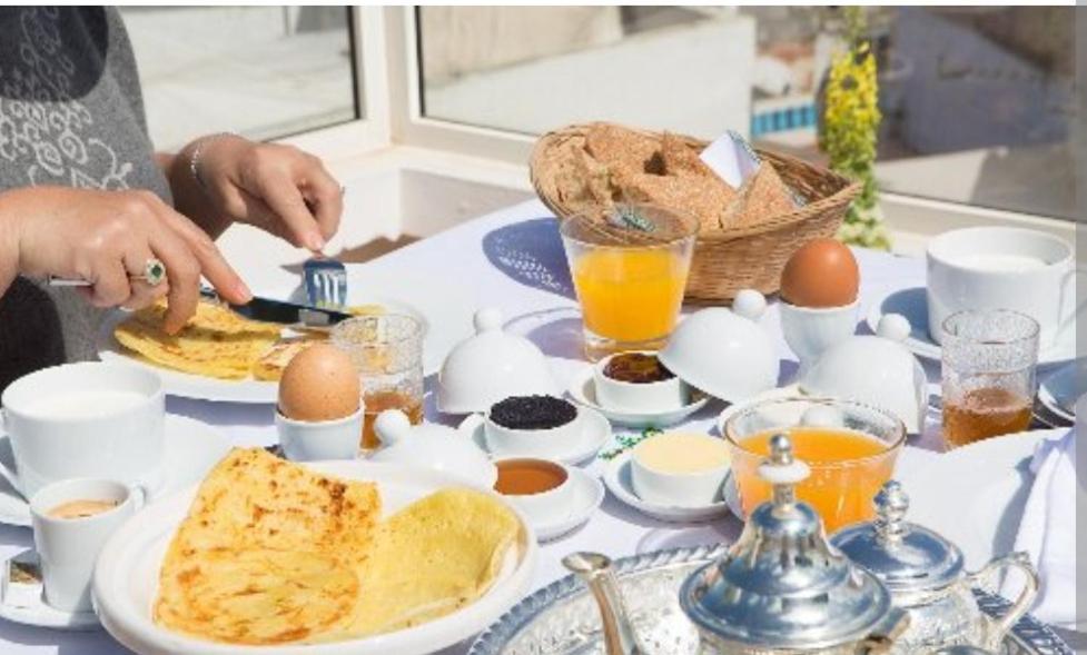 een tafel met eieren en ontbijtproducten erop bij Riad dar salam in Agadir
