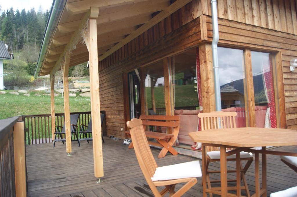 eine Holzterrasse mit einem Tisch und Stühlen darauf in der Unterkunft The Lodge in Stadl an der Mur