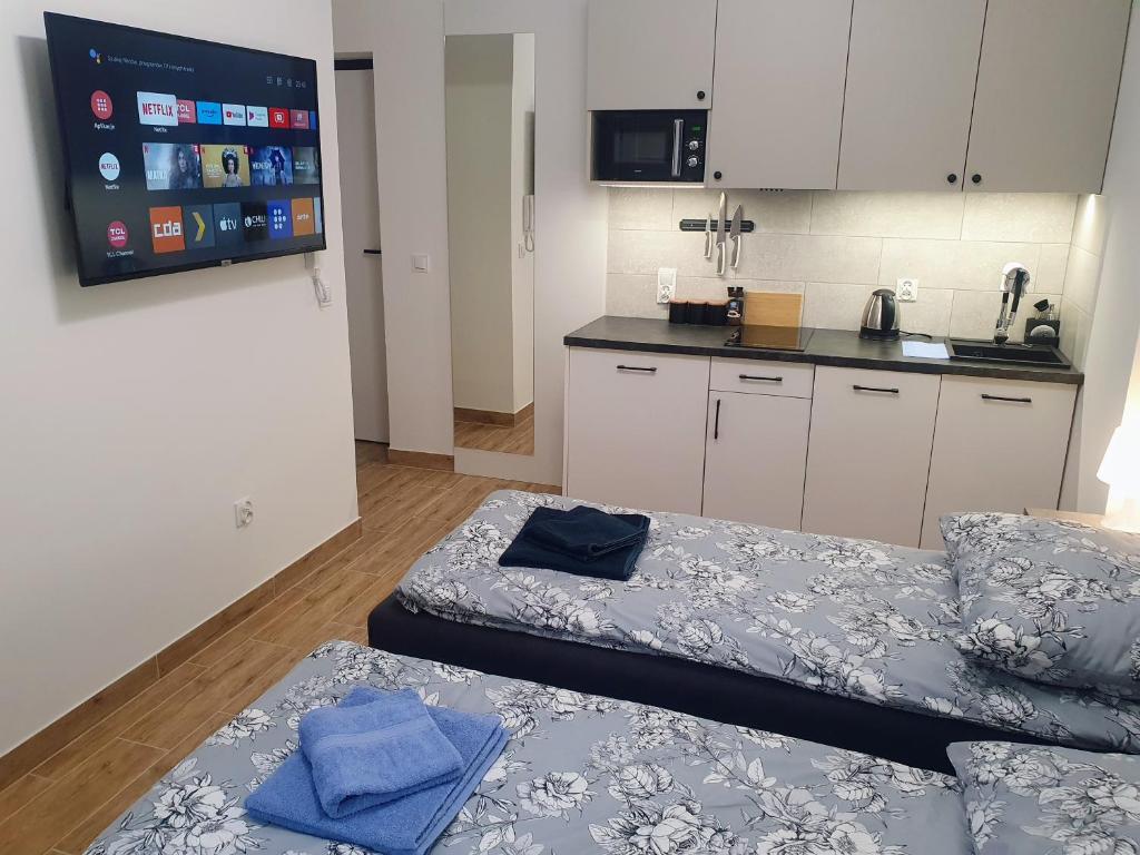 um pequeno quarto com 2 camas e uma cozinha em Apartamenty u Portera w Śródmieściu em Gdynia