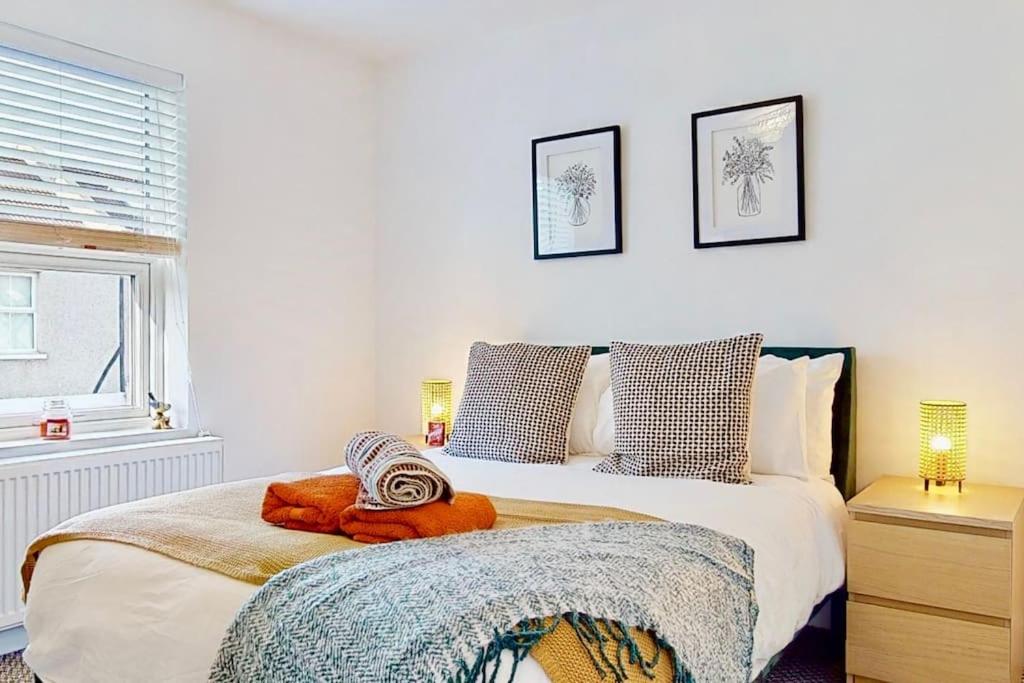 Un dormitorio con una cama grande y una ventana en Charming Victorian Terrace House Quick Walk to Station, en Kent