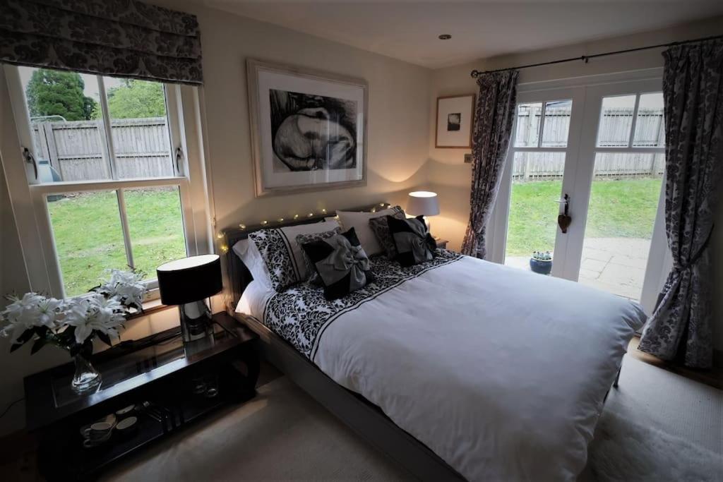 a bedroom with a large bed and windows at Loch Lomond Unique Selfcontained bed+bathroom in Alexandria