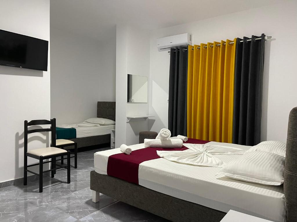 a bedroom with a bed and a yellow curtain at Hotel SEADEL in Ksamil