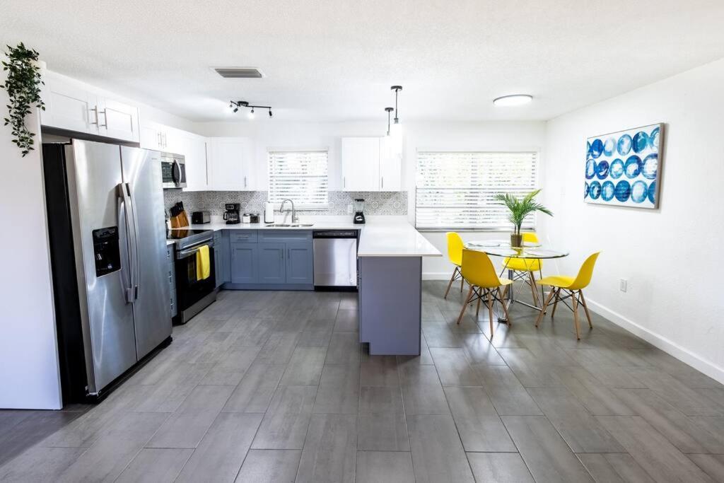 uma cozinha com um frigorífico e uma mesa com cadeiras amarelas em Close to Port Cruise, steps to Wynwood. Up to 8 pp em Miami