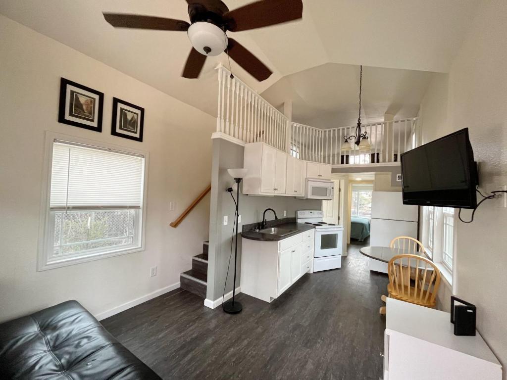 eine Küche und ein Wohnzimmer mit einem Deckenventilator in der Unterkunft Cedar Tiny Home in Woodland Park