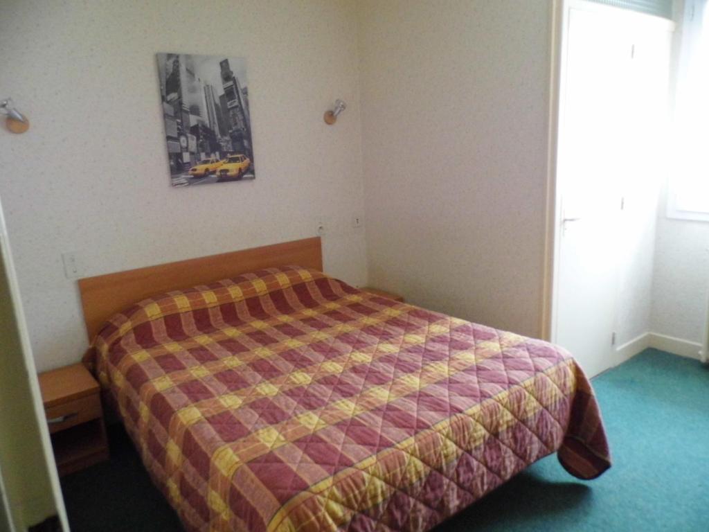 a bedroom with a bed with a checkered blanket at A L'Orée du Bois in Bellerive-sur-Allier