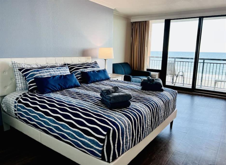 um quarto com uma cama e vista para o oceano em *OCEANFRONT SUNNY FUN*Queen Beds *Great Pools, Hot Tubs+*M44 em Myrtle Beach