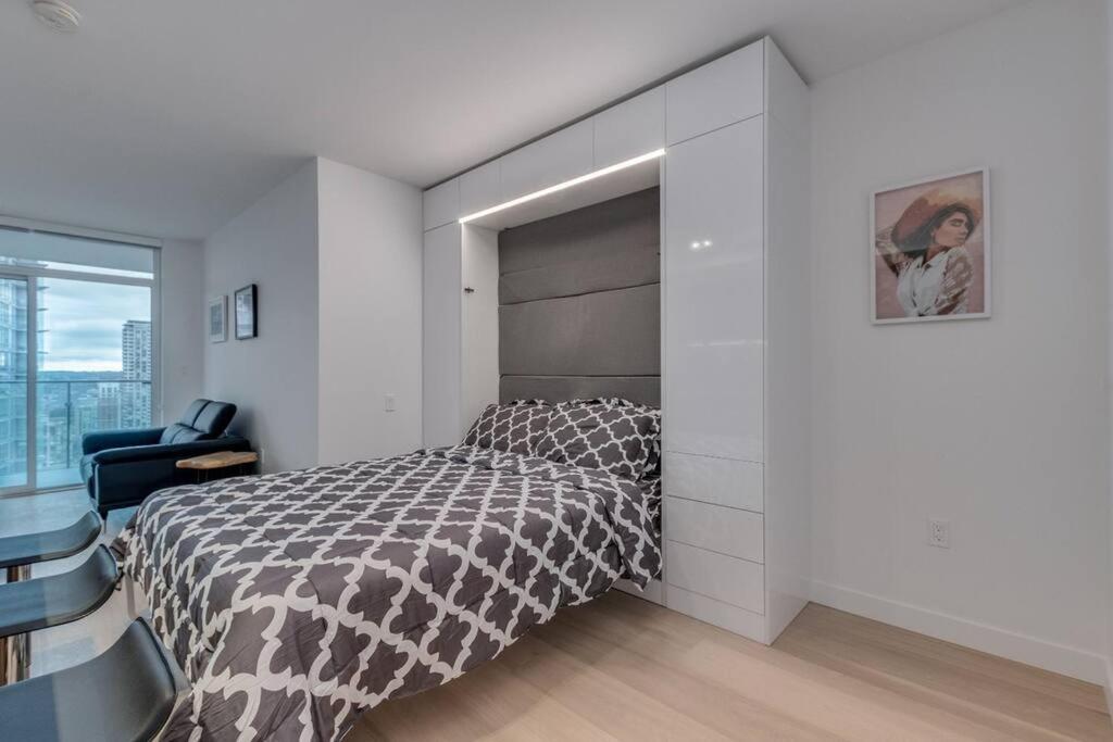 a bedroom with a bed with a large headboard at Modern studio in Downtown Vancouver in Vancouver