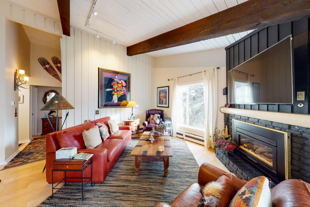 a living room with a couch and a fireplace at Peaceful Woodbridge Hideaway in Snowmass Village