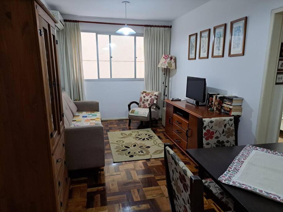 un salon avec une table et un salon avec une télévision dans l'établissement Apartamento a 50m da praia, à Balneário Camboriú