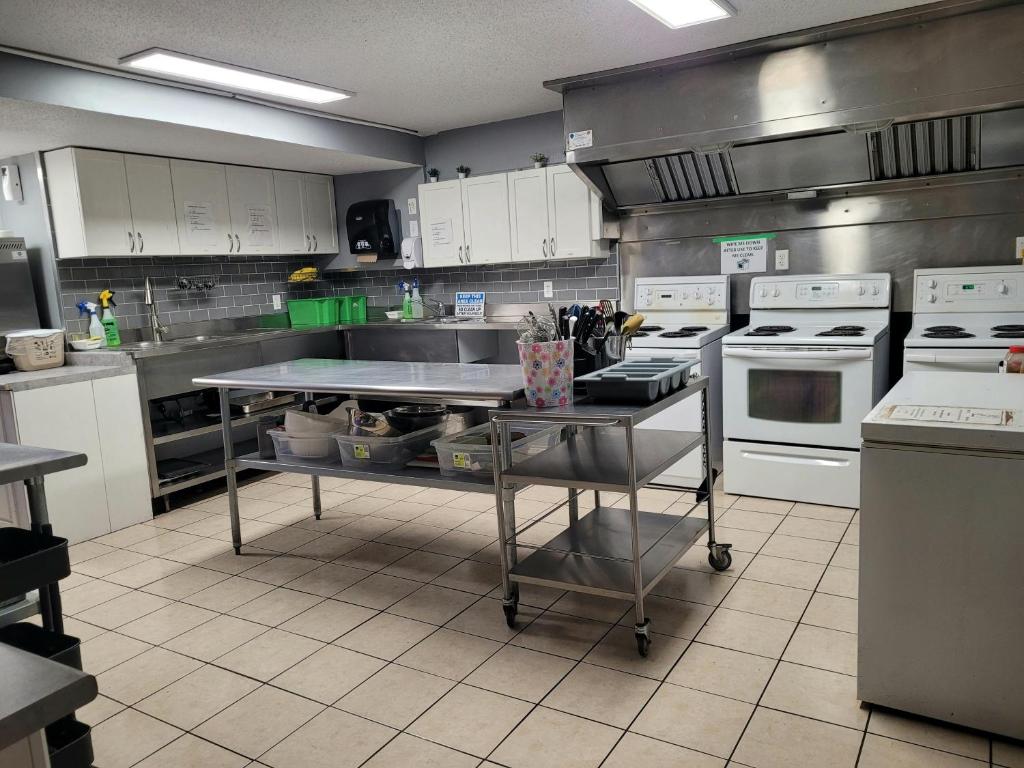 a kitchen with white appliances and a table in it at Banff International Hostel in Banff