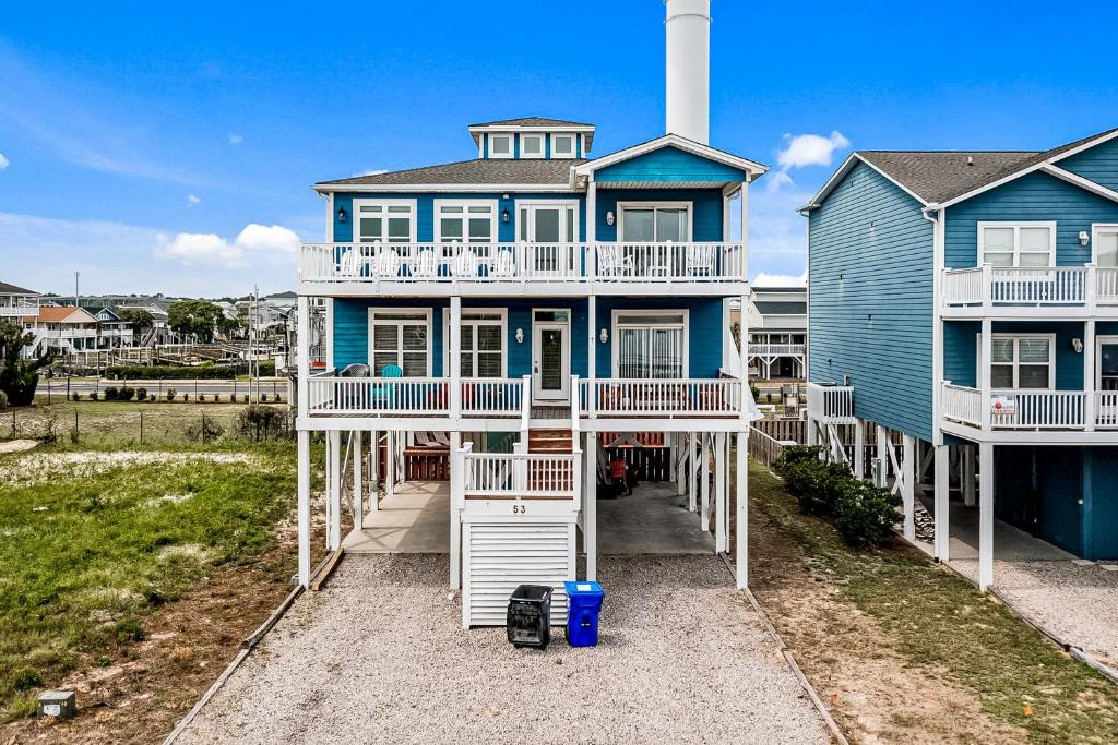 a large blue house with white railings on a beach at Escape to Ocean Isle in Ocean Isle Beach
