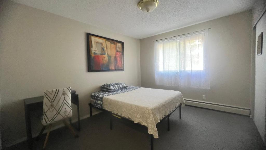 a small bedroom with a bed and a window at Private Room in Oliver 104 ave, Across Grand McEwan University, Norquest College, A Chic Location! in Edmonton