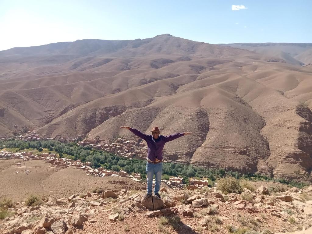 a man standing on top of a mountain with his arms out at Auberge NICE VIEW DADES in Akhendachou nʼAït Ouffi