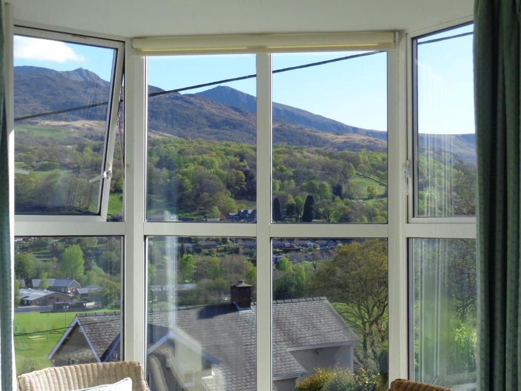 una ventana con vistas a la montaña desde una casa en Staylittle Farm, en Dolgellau