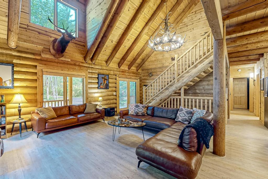 a living room with leather furniture in a log cabin at Misty Mountain Lodge in Tillamook