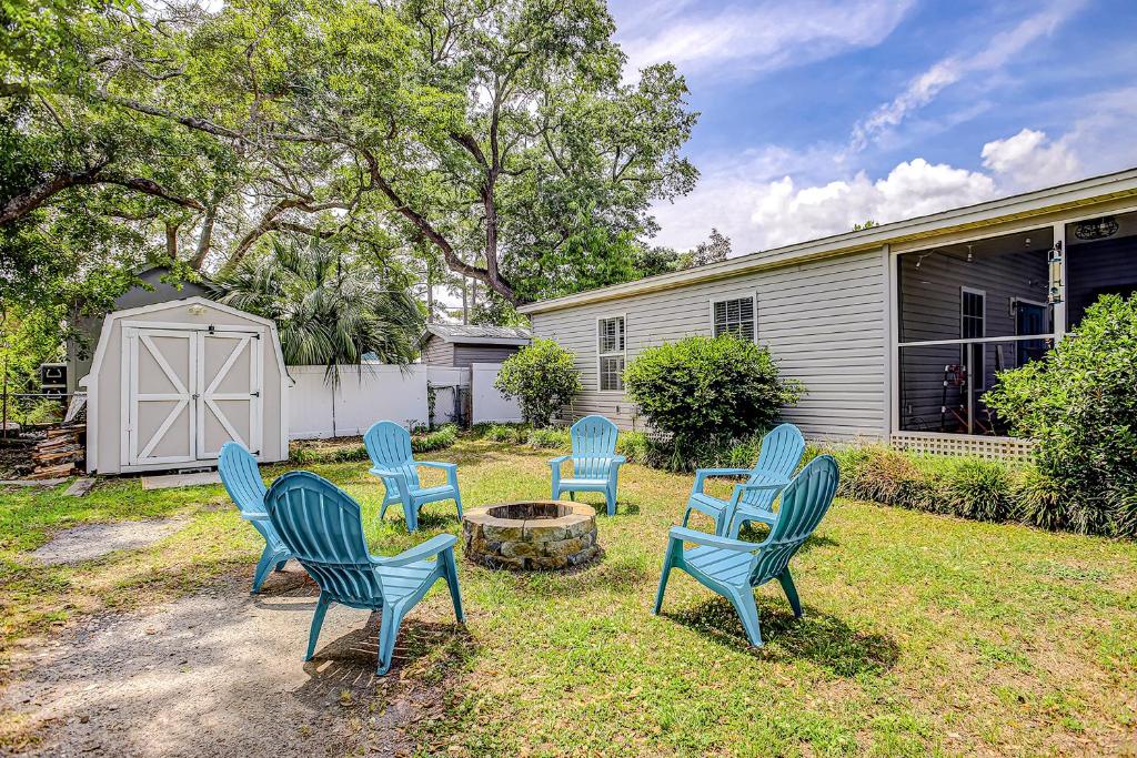 a group of blue chairs sitting in a yard at Pura Vida - 2 Houses - Murrells Inlet in Myrtle Beach
