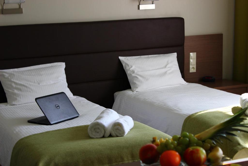 a hotel room with two beds with towels and a laptop at Hotel Pod Dębem in Tarnów